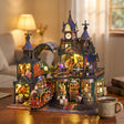 The Clocktower Emporium lit up on a wooden desk at dusk beside tea and books
