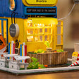 Close up of the glowing yellow cafe front with awning lights and succulent planter