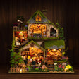 The Mossgrove Cottage glowing on a dark walnut shelf at night