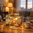 The Pet Club miniature kit lit up on a wooden desk beside a mug of tea