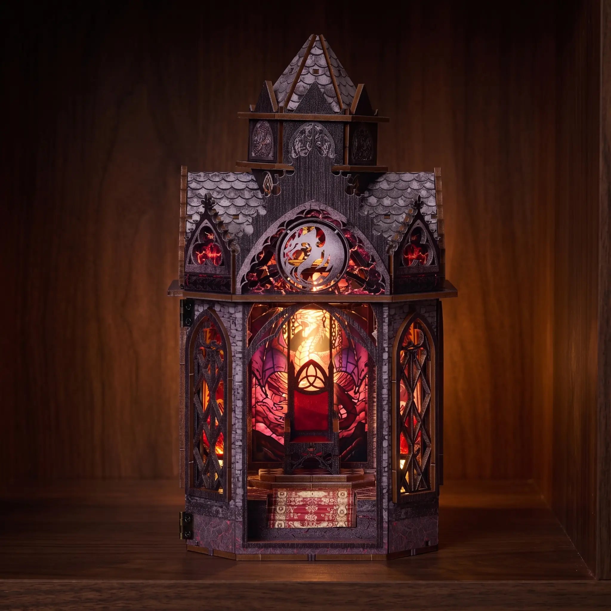 The Dragonspire lit book nook glowing on a dark walnut shelf