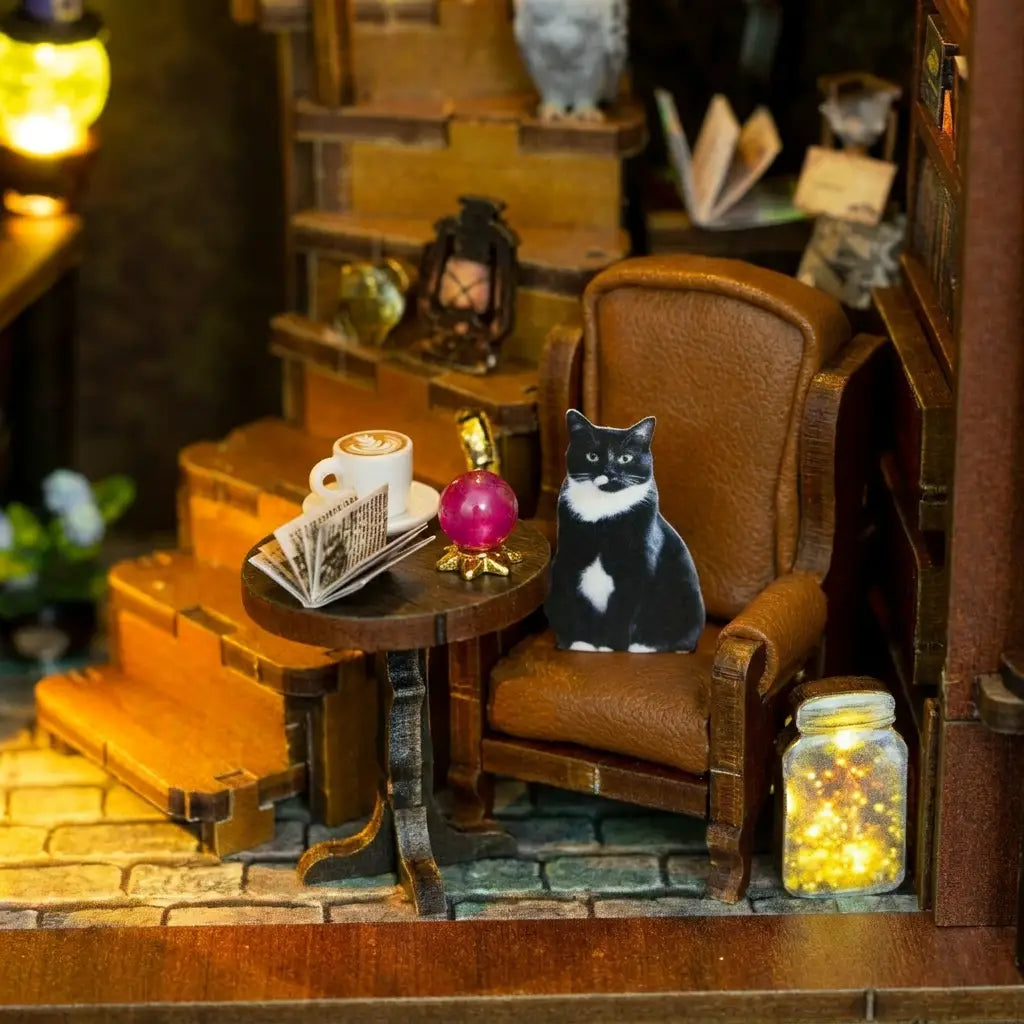 Reading corner detail of The Moonlit Brew with tuxedo cat and crystal ball