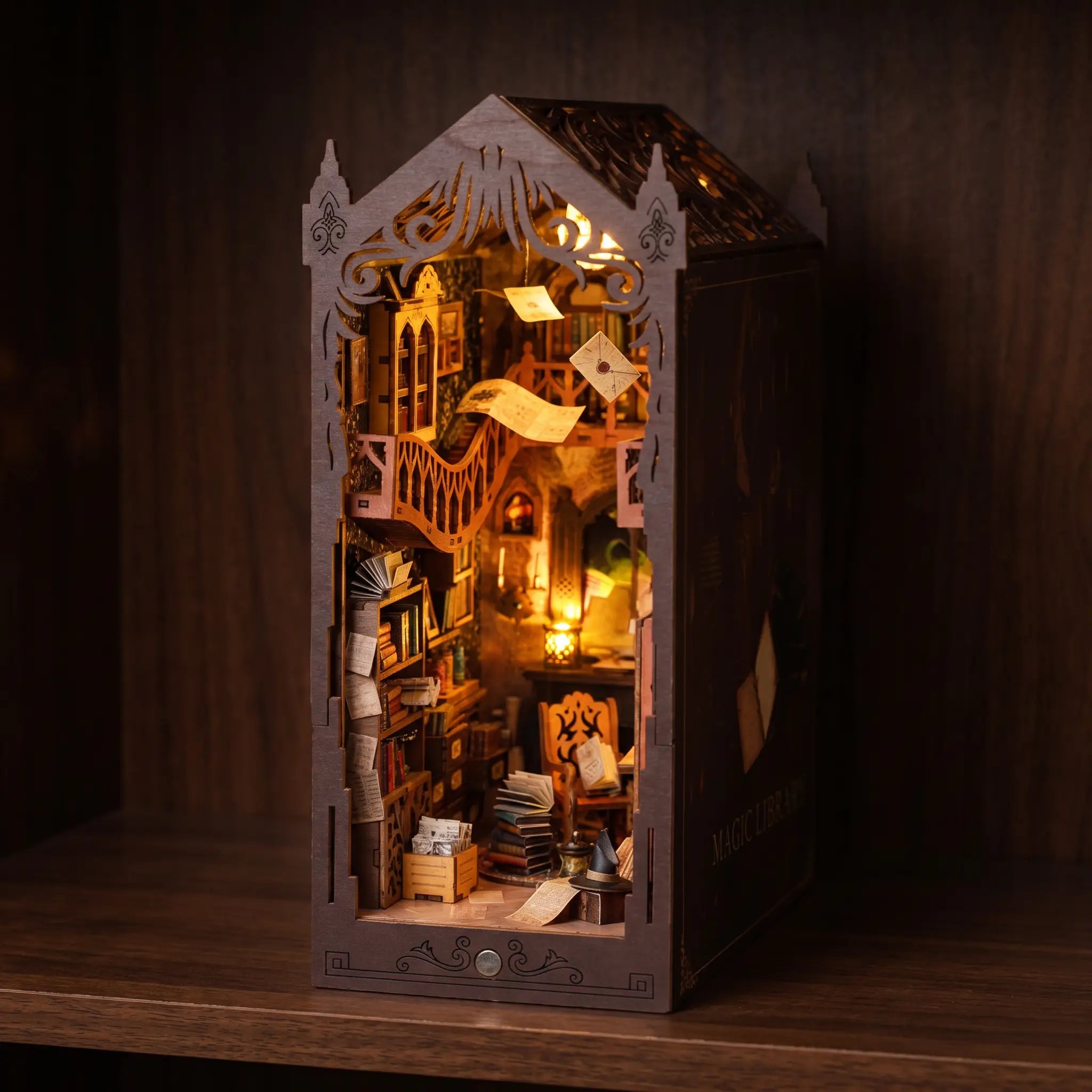 The Sorcerer's Archive book nook glowing on a dark walnut shelf at night