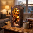 The Sorcerer's Archive book nook on a wooden desk at dusk beside a mug of tea