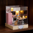 The Breakfast Bar pastel kitchen roombox glowing on a dark walnut shelf at night