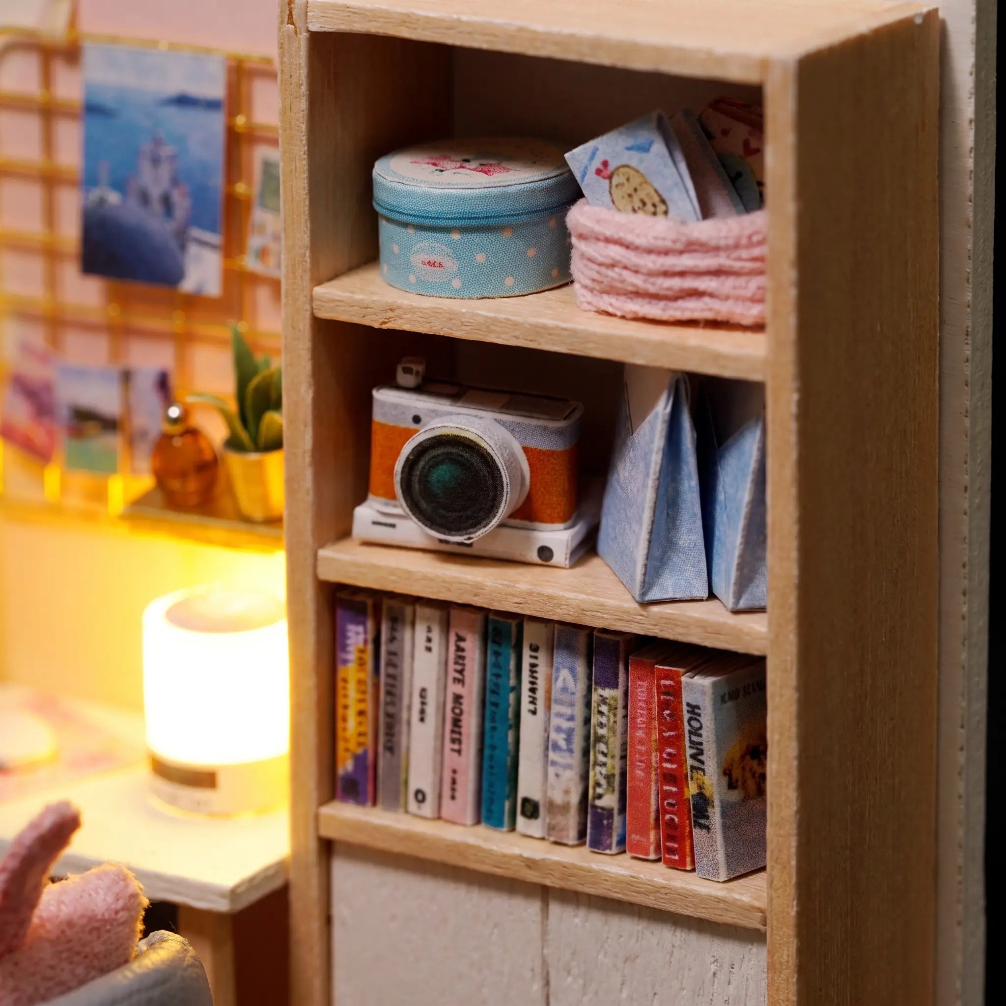 Macro detail of the bookshelf with tiny books and toy camera inside The Daydream Desk kit