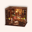 The Left Bank Study miniature Parisian study roombox on a soft cream background, warm interior lighting