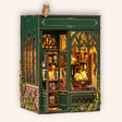 The Owl Bookshop DIY book nook kit, green Victorian corner bookshop with perched owl and stained glass, on a cream background