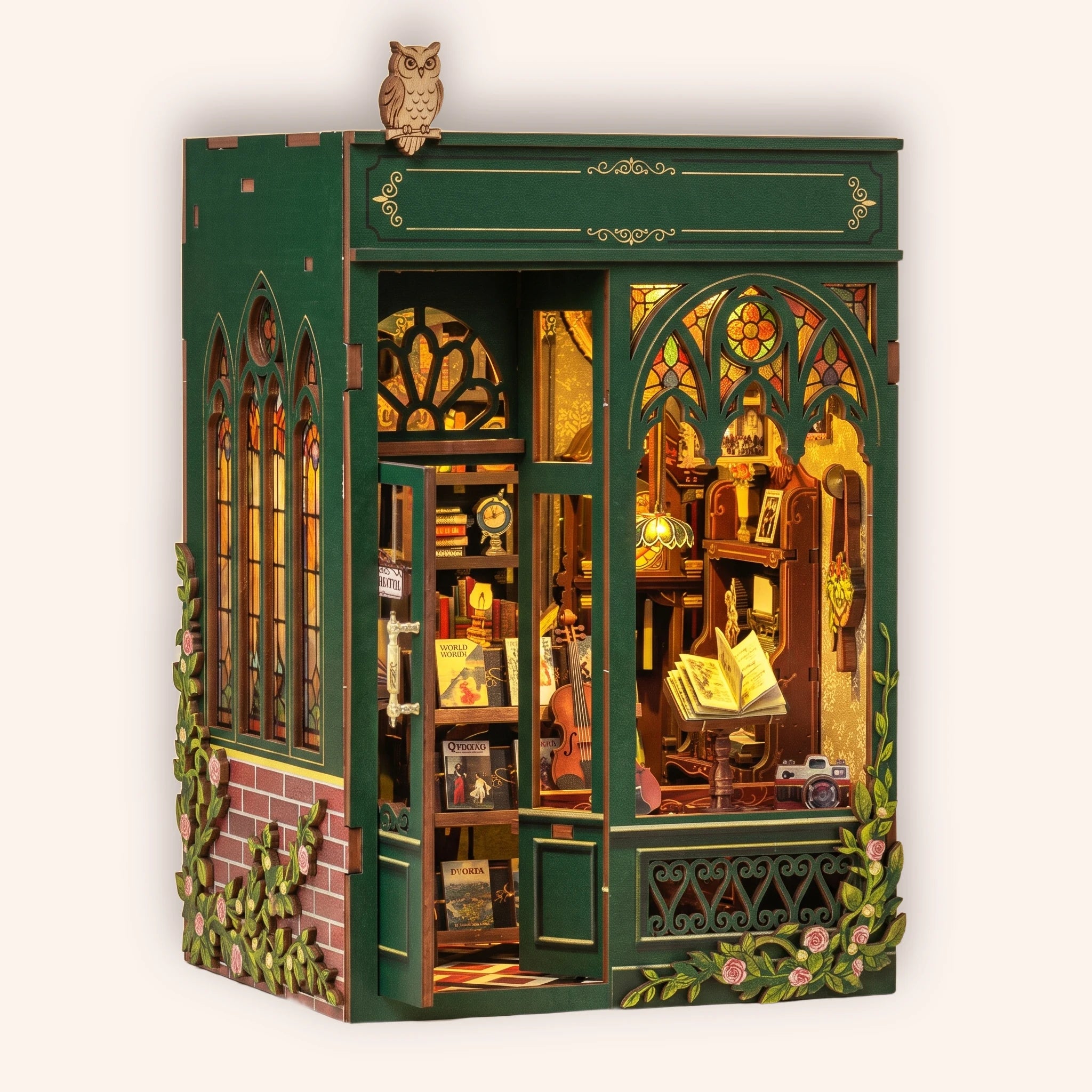 The Owl Bookshop DIY book nook kit, green Victorian corner bookshop with perched owl and stained glass, on a cream background