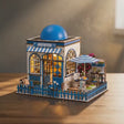 The Santorini Café miniature Greek coffee shop with its blue domed roof, slowly rotating on a warm tabletop with soft lighting