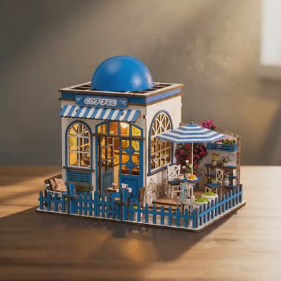 The Santorini Café miniature Greek coffee shop with its blue domed roof, slowly rotating on a warm tabletop with soft lighting