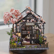 The Sakura Teahouse DIY miniature kit showcase, lit and rotating on a bright tabletop