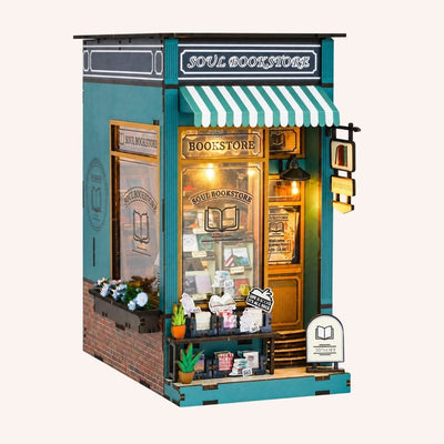 Hands assembling The Corner Bookstore book nook, ending with the LED lights switching on