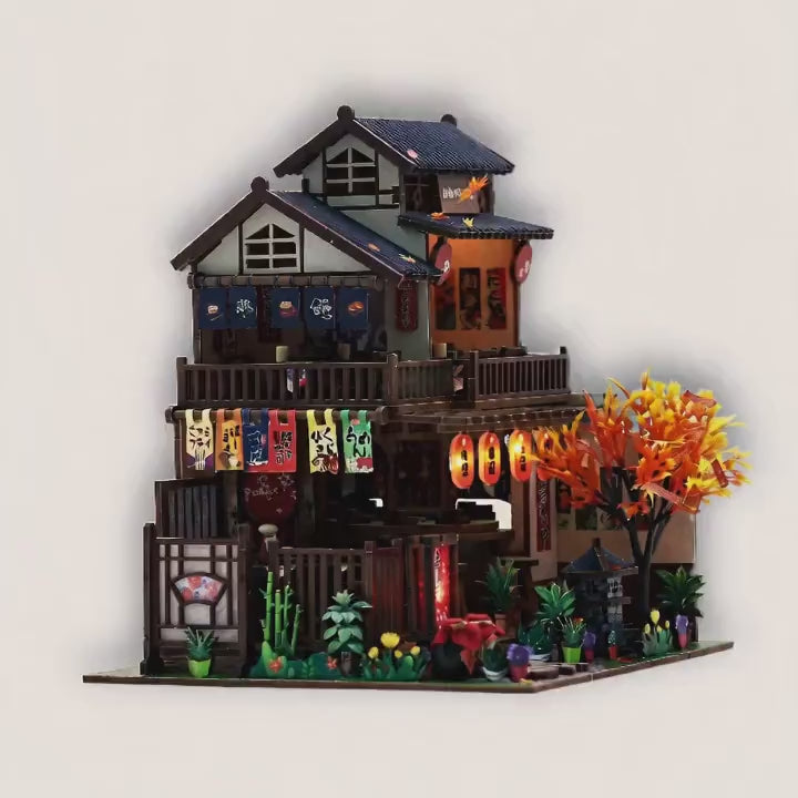 The Maple Teahouse lit miniature slowly revealed on a bright cream studio background