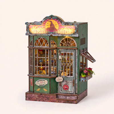 Hands assembling The Enchantment Shop book nook, ending with the shop sign and windows lighting up