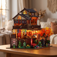 The Maple Teahouse lit miniature slowly revealed on a bright cream studio background