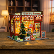 Hands assembling The Sugarplum Shop miniature candy store, ending with the LED lights switching on