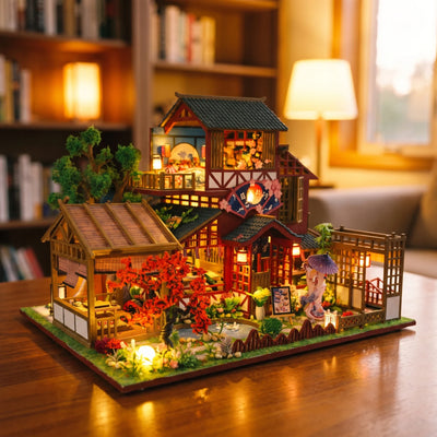 Hands assembling The Autumn Courtyard kit, ending with the LED lights switching on