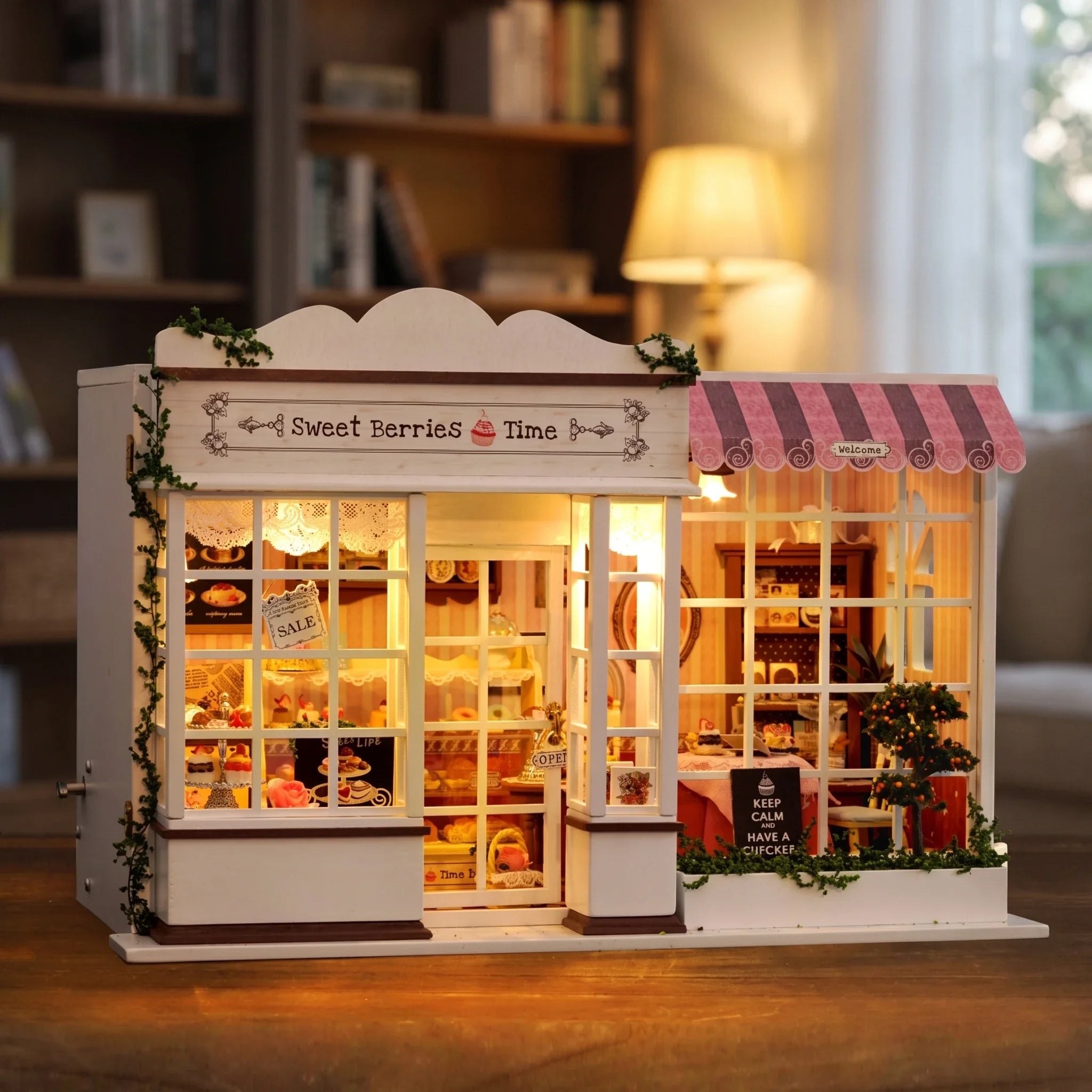 Hands assembling The Berry Bakehouse miniature kit, ending with the lights switching on