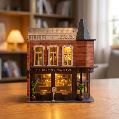 Hands assembling The Gaslight Restaurant miniature kit, ending with the lights switching on