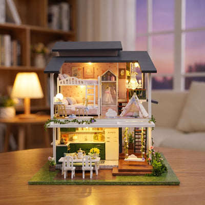 Hands assembling The Giverny Villa miniature kit, ending with the chandelier lighting up