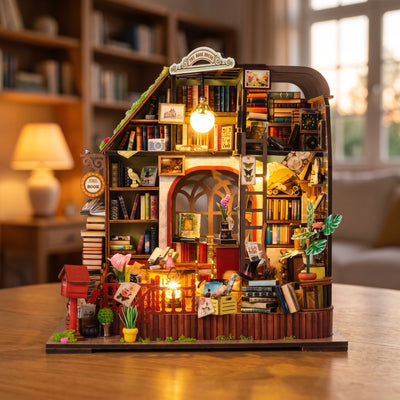 Hands assembling The Lamplight Library miniature kit, ending with the lamp switching on