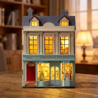 Hands assembling The Paris Boutique miniature kit, ending with the lights switching on