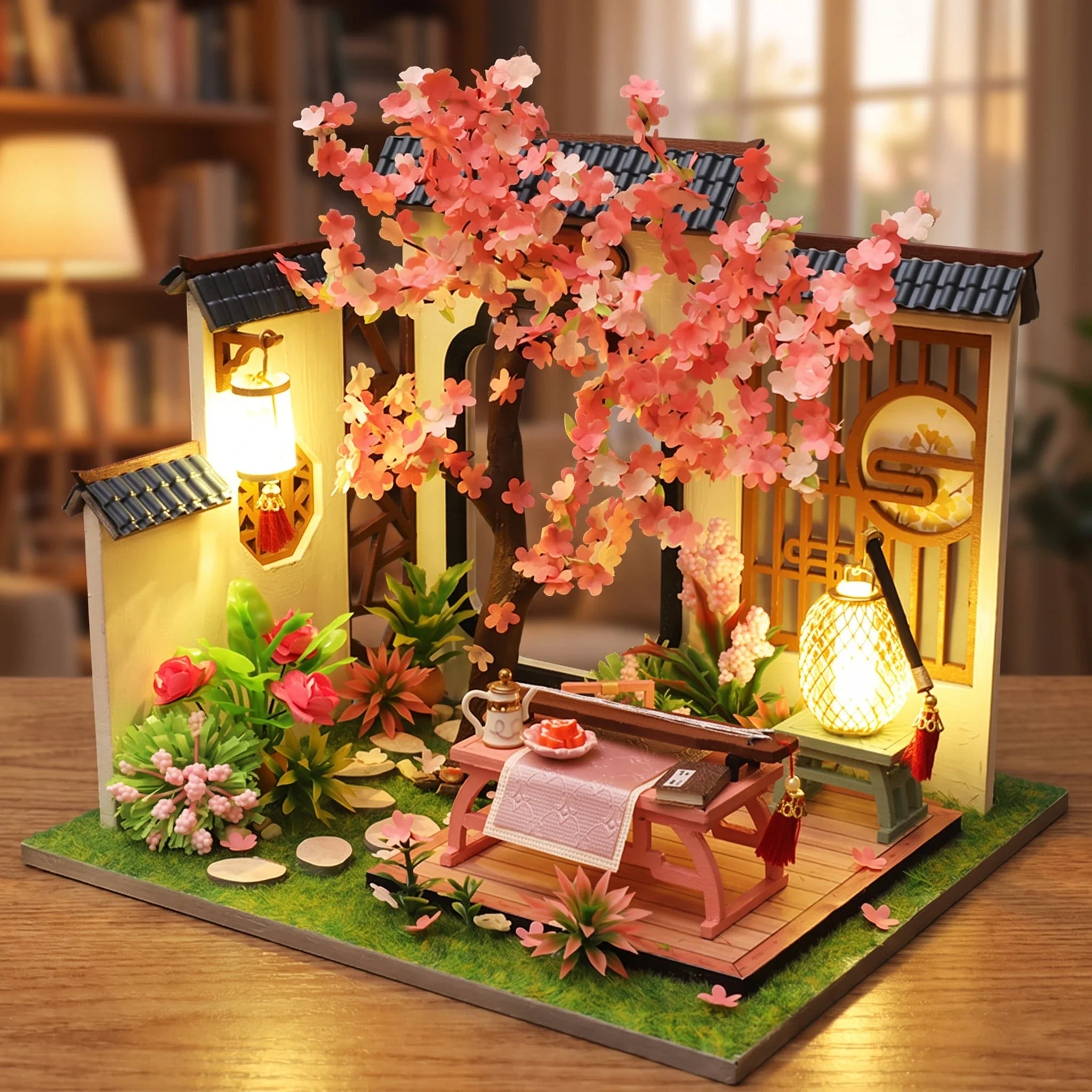 Hands assembling The Petal Courtyard miniature kit, ending with the lights switching on