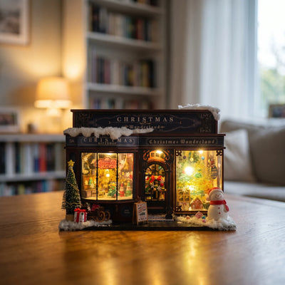 Hands assembling The Tinsel Emporium miniature kit, ending with the lights switching on