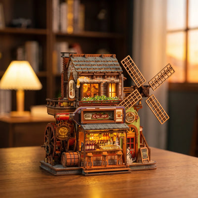 Hands assembling The Windmill Pub, ending with the windmill turning and the lamps on