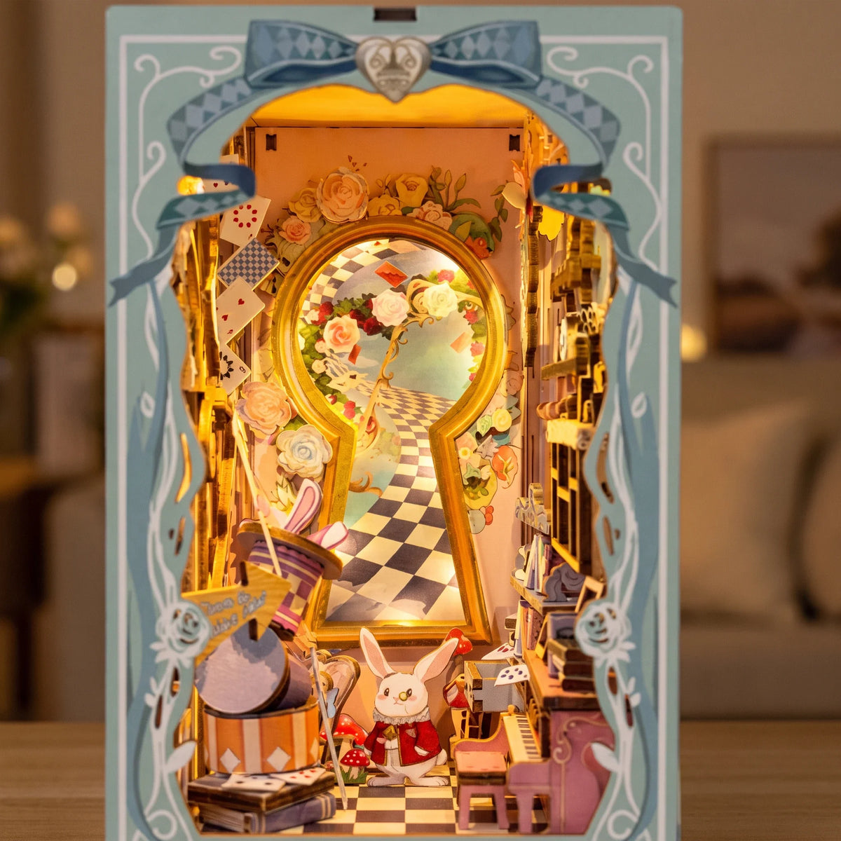 Hands assembling The Wonderland Keyhole book nook, ending with the touch light switching on