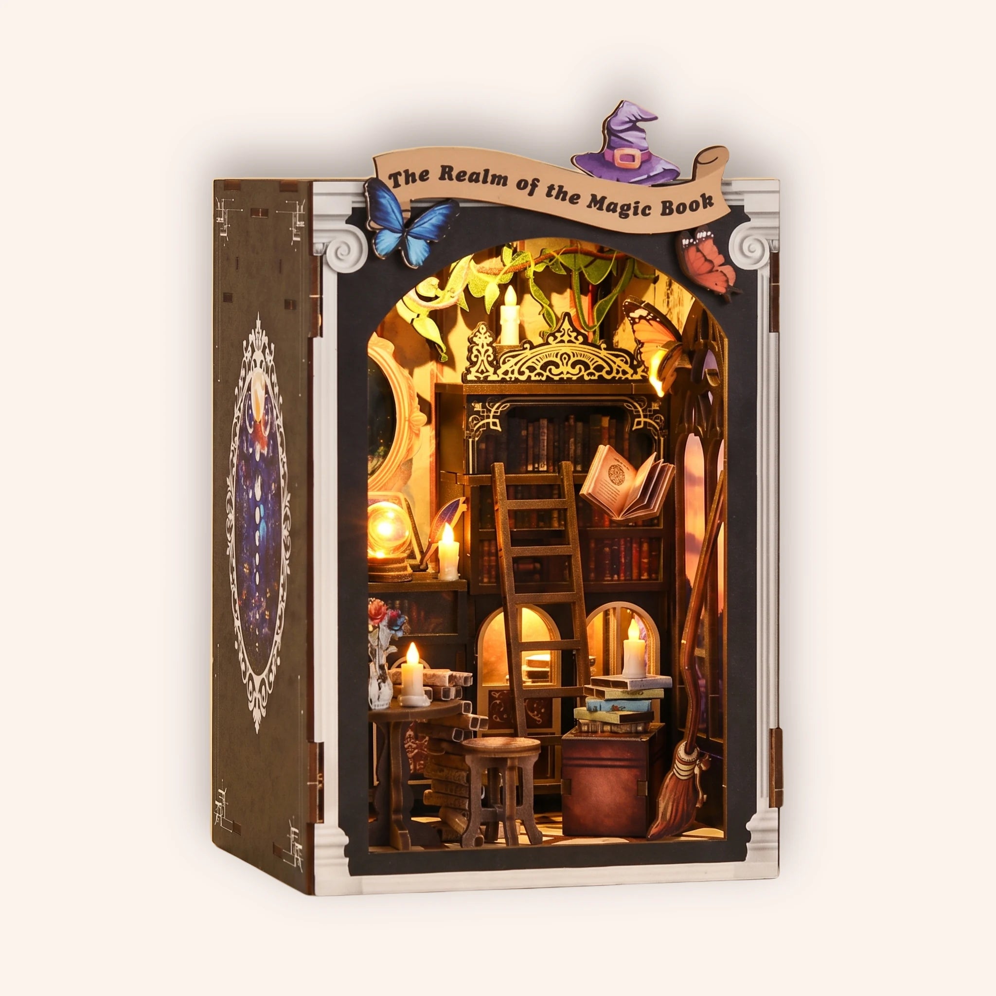The Spellbound Library DIY book nook kit on a soft cream studio background, a cozy wizard's magic library glowing warm amber