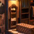 The Tailor's Atelier fitting mirror and bench in warm LED light