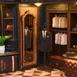 The Tailor's Atelier display area with flat printed suit panels beside the wooden mirror frame