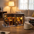 The Alchemist's Cafe on a desk at dusk beside a mug of tea