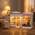 The Berry Bakehouse on a desk at dusk beside a mug of tea