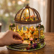 A hand places a potted flower on The Bloom Rotunda steps, true 10 x 8.5 x 9.6 inch scale