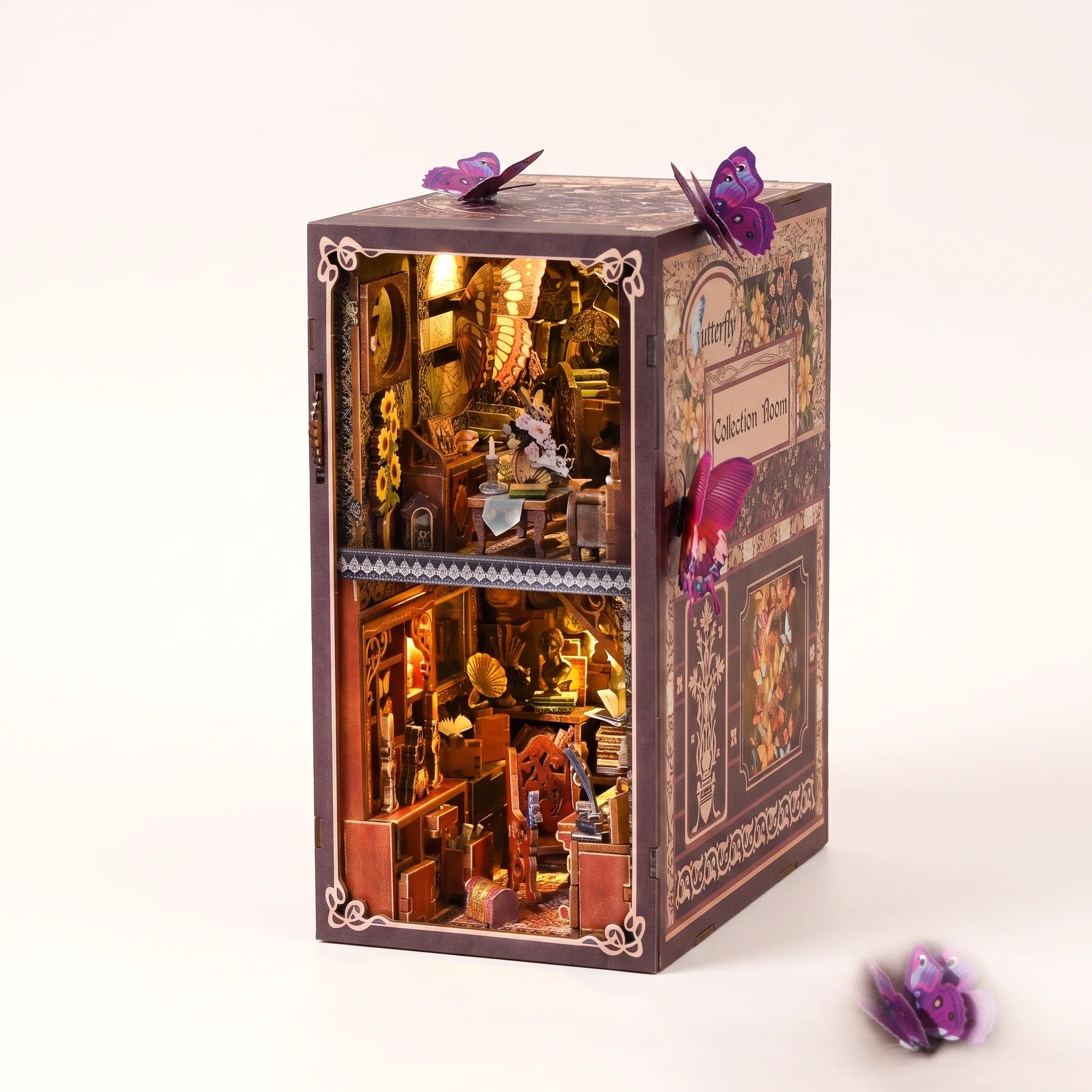 The Butterfly Archive book nook kit on a pale blush studio background with LED lights on