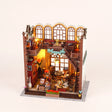 The Crystal Quill DIY miniature wizard bookshop kit with LED lights on, pale blush studio hero
