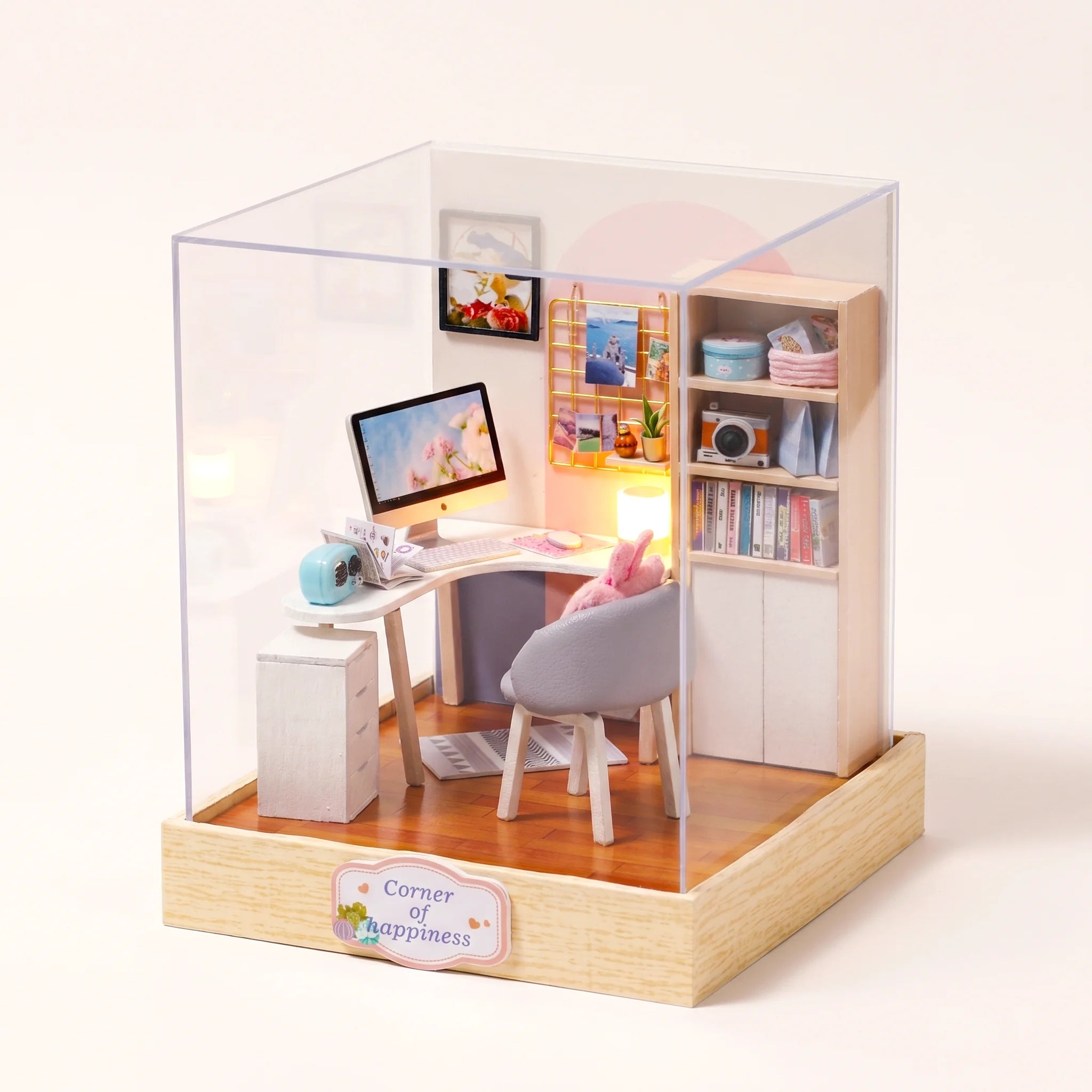 The Daydream Desk DIY miniature study kit assembled with LED lamp on, on a pale blush backdrop