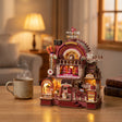 The Dessert Engine lit on a desk at dusk beside a mug of tea