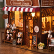 Detail of the cake counter with tiny cakes, dessert jars and chalkboard menus