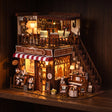 The Dessert House glowing at night on a dark walnut shelf