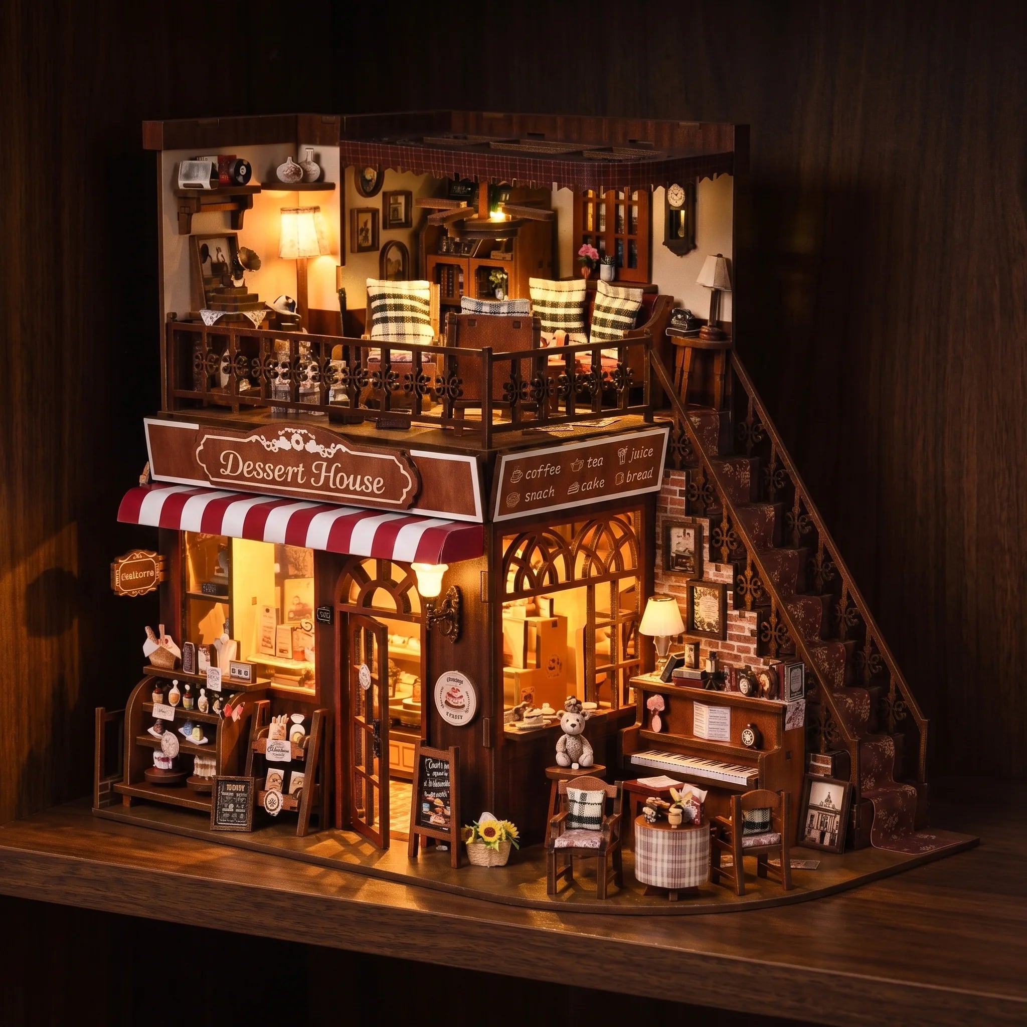 The Dessert House glowing at night on a dark walnut shelf