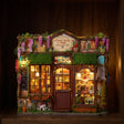 The Dollhouse Shop glowing on a dark walnut shelf at night