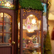 Detail of the glowing castle lamp and teddy bear in The Dollhouse Shop display window