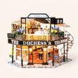 The Duchess's Tea Room DIY miniature kit with LED lights glowing on a pale blush studio background