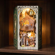 The Emerald Road book nook glowing on a dark walnut shelf at night