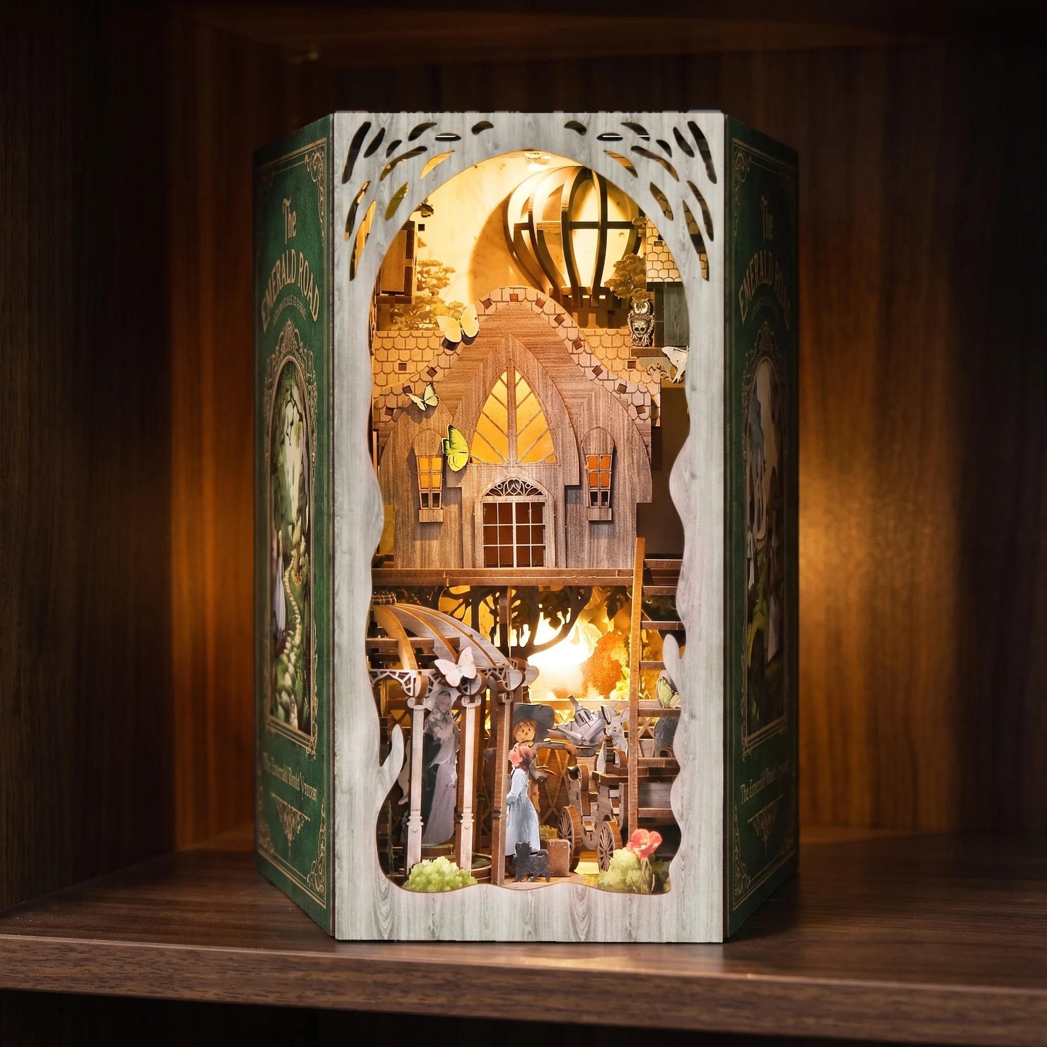 The Emerald Road book nook glowing on a dark walnut shelf at night