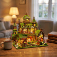 The Foxglove Manor lit on a desk at dusk beside tea and books